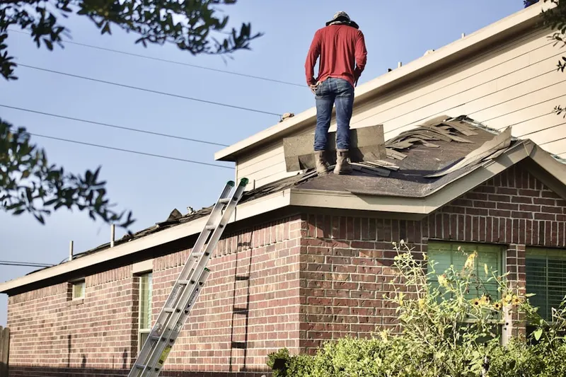 Professional roofer working on a residential roof in EspaÃ±ola